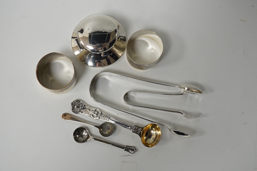 A modern silver capstan inkwell, two silver napkin rings and five items of silver cutlery including a pair of William IV sugar tongs. Condition - fair to good